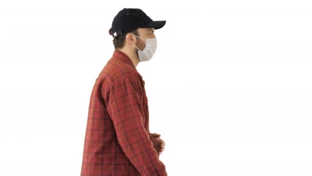 American farmer in a cap and medical mask walks along on white background. — Stock Video