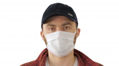 Genç adam beyaz arka planda Başparmağını gösteren bir maske takıyor..