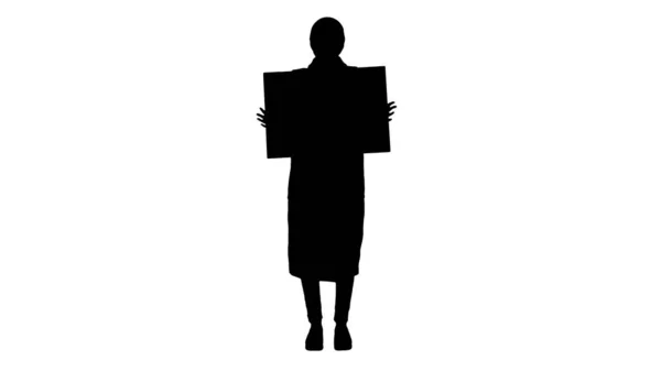Mulher silhueta em roupas ao ar livre e em máscara médica segurando placa em branco . — Fotografia de Stock