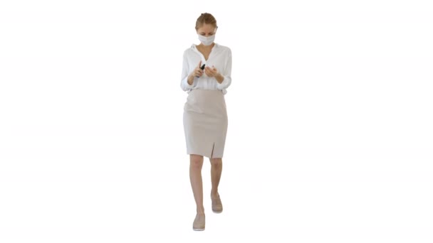 Young woman use the skin sanitizer to protect her hands from any viruses on white background. — Stock Video