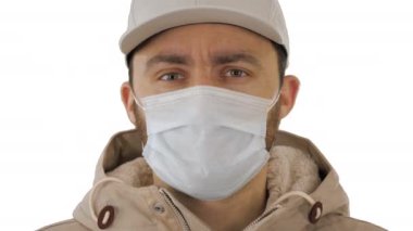 Hasta genç adam beyaz arka planda tıbbi maske takıyor..