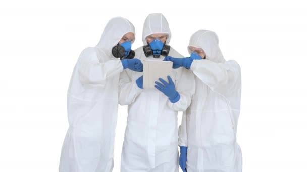Médicos o científicos que usan trajes de materiales peligrosos trabajando juntos en tabletas digitales sobre fondo blanco . — Vídeos de Stock