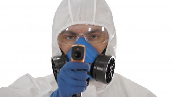 Doctor in beschermende biohazard suit wijst laserthermometer om uw temperatuur te controleren op een covid19 checkpoint op witte achtergrond. — Stockvideo