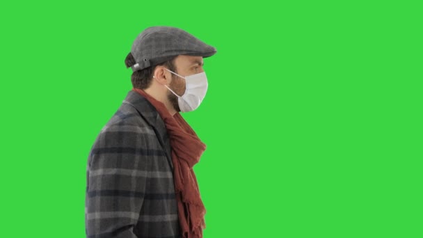 Κύριος φορώντας μια προστατευτική μάσκα προσώπου περπατώντας σε μια πράσινη οθόνη, Chroma Key. — Αρχείο Βίντεο