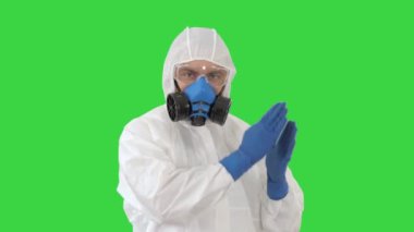 Hazamat giysili doktor yeşil ekran, krom anahtar üzerinde komik bir Covid-19 konseptiyle dans ediyor..