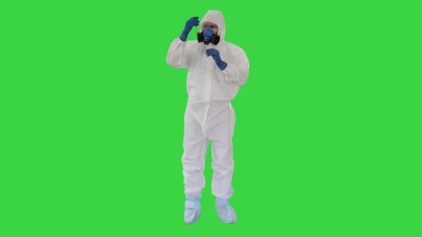 Lékař v Hazmat obleku a plynové masky držení zkumavky krve na zelené obrazovce, Chroma klíč. — Stock video