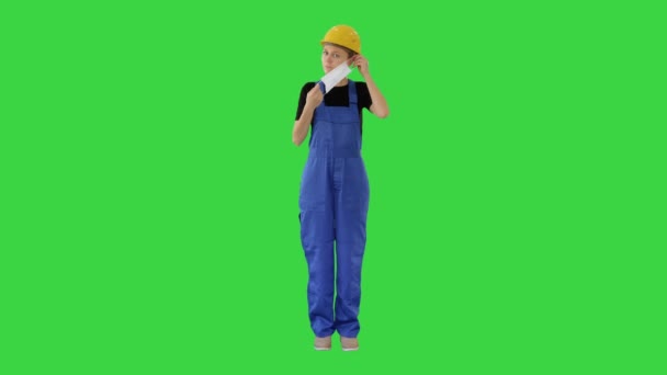Bauarbeiterin setzt medizinische Maske auf einem Green Screen auf, Chroma Key. — Stockvideo