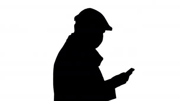 Silhouette Homme adulte porte un masque médical protecteur parlant au téléphone et marchant. — Video