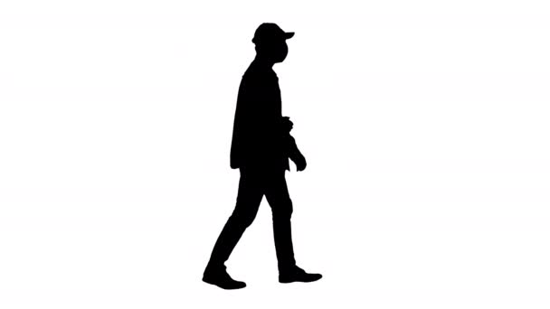 Silhouet Amerikaanse boer met een pet en medisch masker loopt langs. — Stockvideo