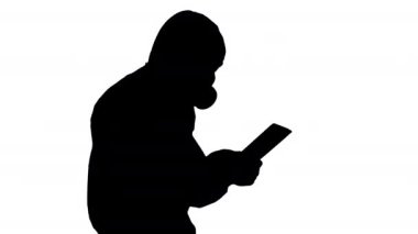 Siluet bilimcisi ya da doktor yürürken biyolojik tehlike giysileri ve koruyucu maskeler giyip dijital tablet kullanıyor..