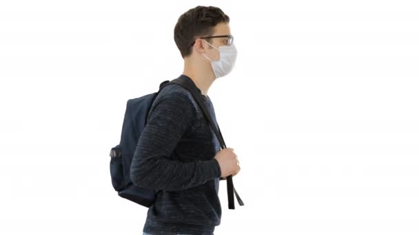 Student in protective masks walking with backpack on white background. — Stock Video