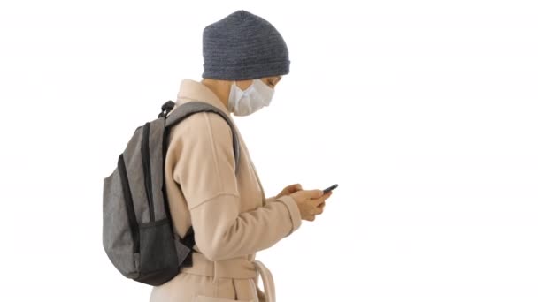 Mulher usando máscara médica andando sobre fundo branco . — Vídeo de Stock