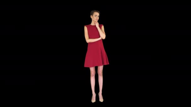 Atractiva joven vestida de rojo de pie y escuchando a alguien hablar, Alpha Channel — Vídeo de stock