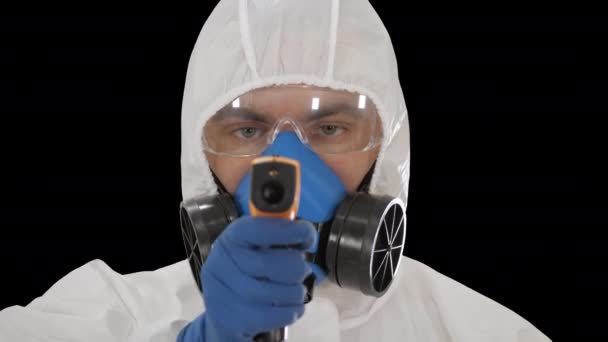 Arzt im Biohazard-Schutzanzug zeigt Laserthermometer an, um Ihre Temperatur an einem covid19 Checkpoint, Alpha Channel, zu überprüfen — Stockvideo