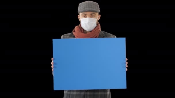 Man i en trendig outfit och medicinsk mask med tomt plakat, Alpha Channel — Stockvideo
