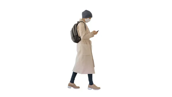 Vrouw dragen medisch masker lopen op witte achtergrond. — Stockfoto
