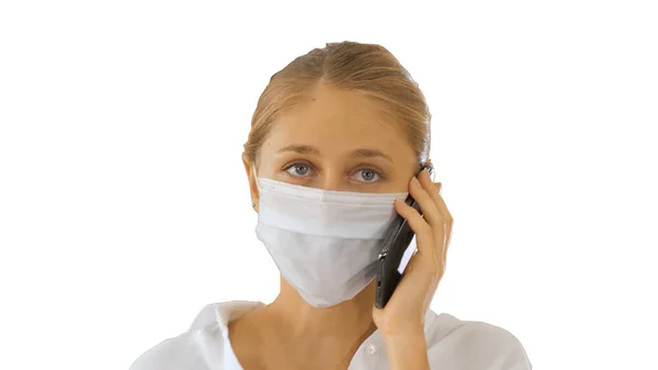 Mujer joven con máscara facial protectora haciendo una llamada caminando sobre fondo blanco . —  Fotos de Stock