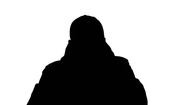 Silhouette Mann im warmen Mantel geht und setzt medizinische Maske auf. — Stockfoto