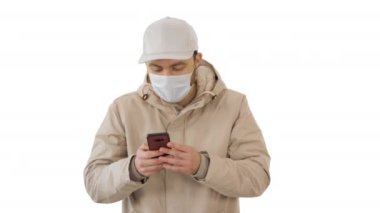 Genç sıradan bir adam beyaz arka planda kalın giysiler ve koruyucu bir maske takarak arama yapıyor..