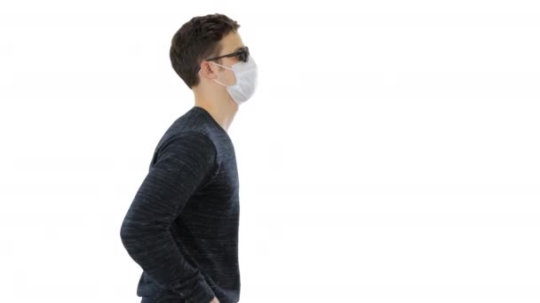 Ung blind person med lång käpp och medicinsk mask promenader på vit bakgrund. — Stockvideo