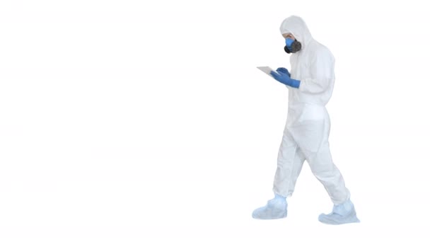 Медицинский работник в защитном костюме работает над цифровым планшетом на белом фоне . — стоковое видео
