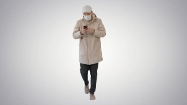 Genç, sıradan bir adam, arka planda kalın giysiler ve koruyucu bir maske takarak arama yapıyor..