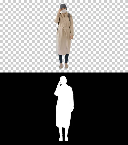 Dziewczyna w masce medycznej stojąca w płaszczu, kanał Alfa — Zdjęcie stockowe