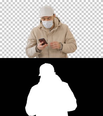 Sıradan bir genç, kalın giysiler ve koruyucu maske takarak Alfa Kanalı 'nda arama yapıyor.