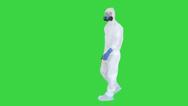 Врач в защитном костюме проверяет температуру на зеленом экране, хрома-ключ . — стоковое видео