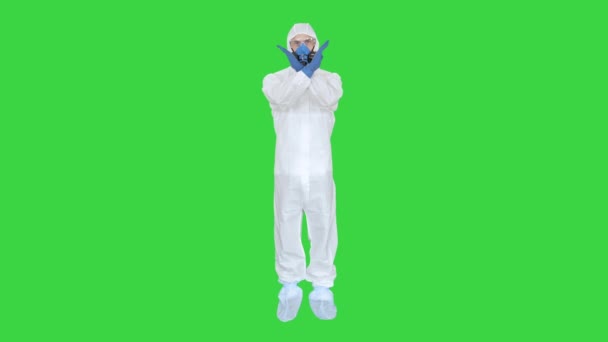Uomo con maschera protettiva e tuta hazmat mani incrociate e mostrando gesto di stop su uno schermo verde, Chroma Key . — Video Stock