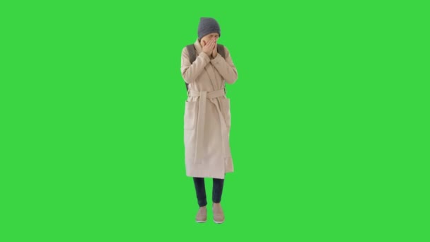 Woman in a coat walking and coughing on a Green Screen, Chroma Key. — Stock Video