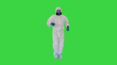 Hazamat takım elbiseli bir adam Yeşil Ekran, Chroma Key 'de yürüyor ve dans ediyor..