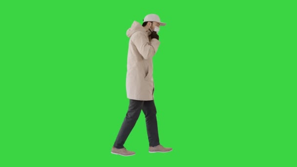 Inverno vestido de homem caucasiano vestindo máscara médica em uma tela verde, Chroma Key . — Vídeo de Stock