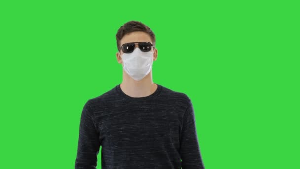 Niewidomy w masce twarzy i ciemnych okularach z chodzeniem po zielonym ekranie, Chroma Key. — Wideo stockowe