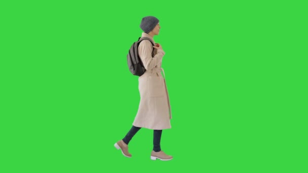 Woman with backpack in outdoor clothes walking and coughing on a Green Screen, Chroma Key. — Stock Video