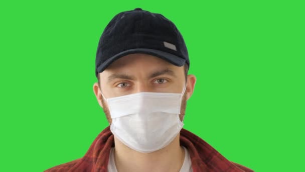 Kaukázusi férfi védőmaszkot visel, rendben van a jel a zöld vásznon, Chroma Key. — Stock videók