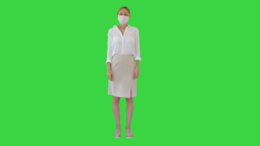 Korumalı tıbbi maskeli bir iş kadını yeşil ekranda, Chroma Key.