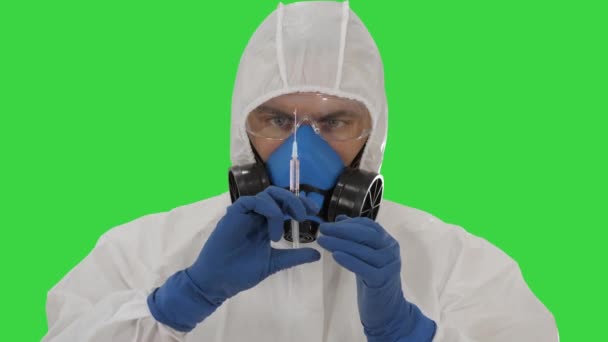 Scientist in protective gear holding syringe with injection on a Green Screen, Chroma Key. — Stock Video