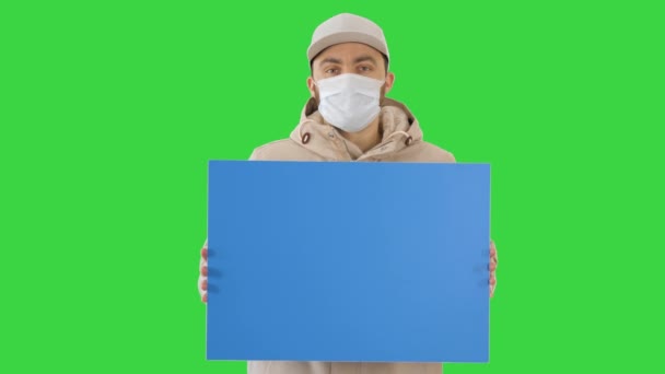 Casual άνθρωπος με αντίγραφο διαφημιστική πινακίδα χώρο φορώντας προστατευτική μάσκα σε μια πράσινη οθόνη, Chroma Key. — Αρχείο Βίντεο