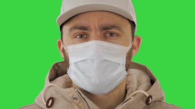 Yeşil Ekran 'da tıbbi maske takan yakışıklı hasta genç adam, Chroma Key.