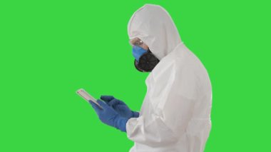 Dijital Tablet, Covid-19 Yeşil Ekran, Krom Anahtar Konsepti ile Koruyucu Kostüm Doktoru.