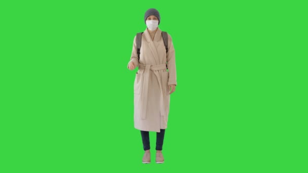 Fille dans un masque médical debout dans un manteau sur un écran vert, Chroma Key . — Video