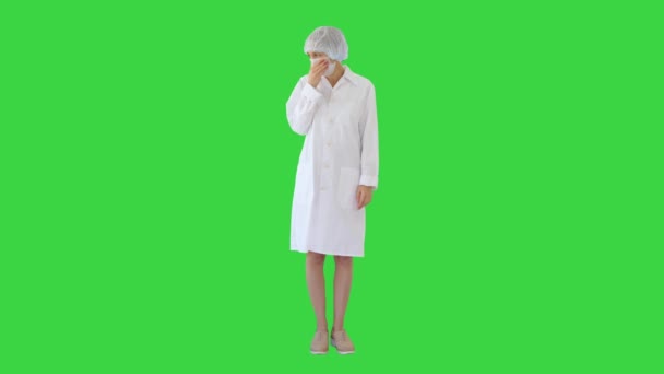 Hoest vrouwelijke arts in een masker om te voorkomen dat anderen van infectie op een groen scherm, Chroma Key. — Stockvideo