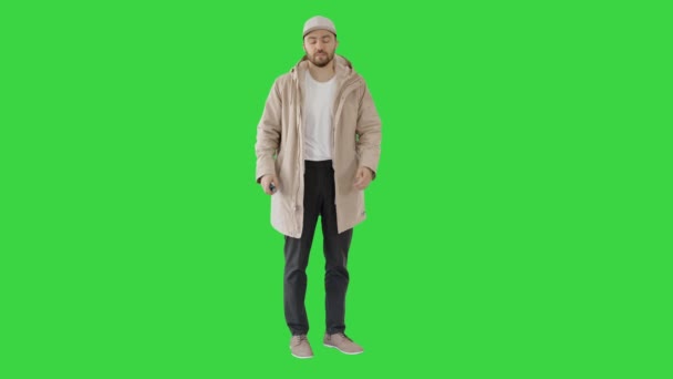 Νεαρός άνδρας που χρησιμοποιεί απολυμαντικό δέρματος για να προστατευτεί από τον ιό σε μια πράσινη οθόνη, Chroma Key. — Αρχείο Βίντεο
