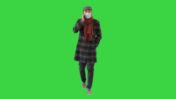 Modischer Herr in medizinischer Maske telefoniert auf einem Green Screen, Chroma Key. — Stockvideo