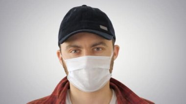 Beyaz adam koruma maskesi takıyor. Gradyan arka planda tamam işareti yapıyor..