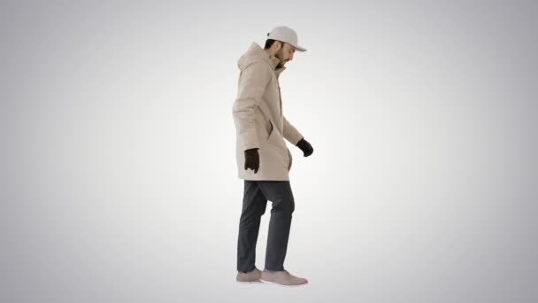 Bell'uomo alla moda in un cappotto elegante invernale che cammina su sfondo sfumato . — Video Stock