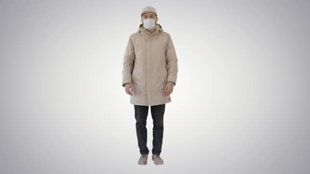 Junger Mann mit Grippe-Maske steht tatenlos vor dem Hintergrund des Gefälles. — Stockvideo