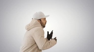 Hip-hop şarkıcısı Rap söylüyor, yürüyor ve gradyan arka planda jestler yapıyor.