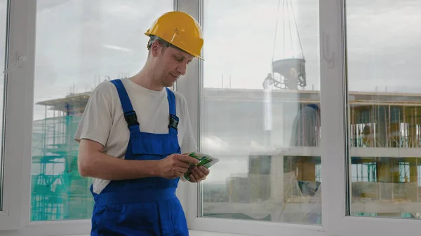 Construction worker counts the money.